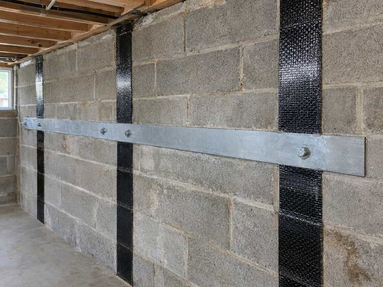 Bowing basement wall reinforced with carbon fiber straps